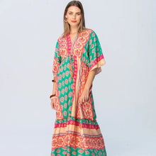 Load image into Gallery viewer, Woman wearing a colorful patterned dress on a light gray background