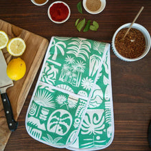 Load image into Gallery viewer, Green and white patterned oven gloves on a wooden table with lemons and spices.