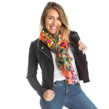Load image into Gallery viewer, Woman wearing a colorful scarf, black jacket, and blue jeans on a white background