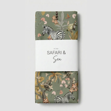 Load image into Gallery viewer, A folded safari-themed fabric table runner, wrapped in a white paper band that reads 'SAFARI & Sea EST. 2022'.
