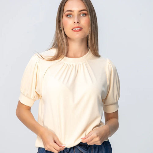 Woman wearing a butter yellow t-shirt against a light gray background