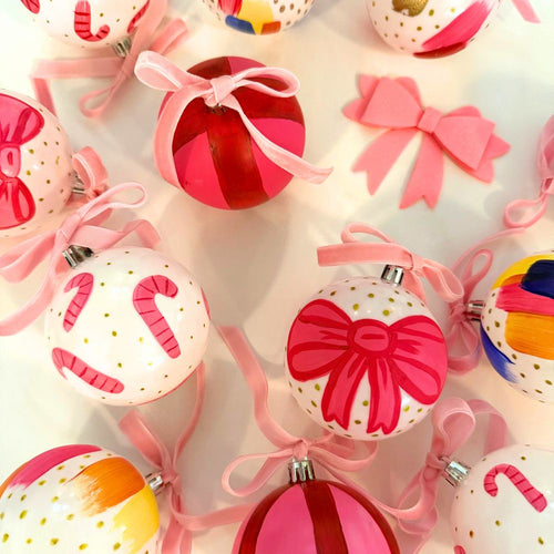 Colorful Christmas ornaments with bows and ribbons on a light background