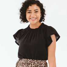 Load image into Gallery viewer, Woman wearing a black top with sheer sleeves against a white background
