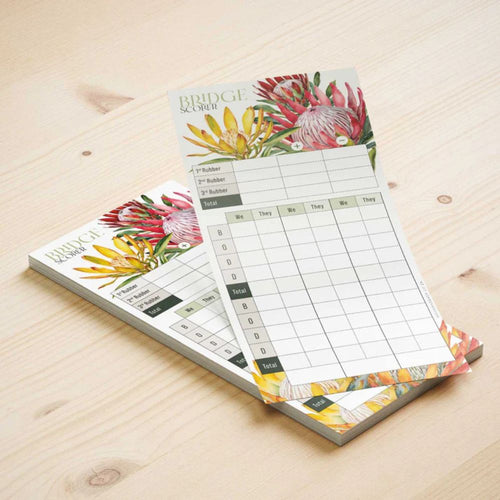 Floral-themed bridge scoring set on a wooden surface