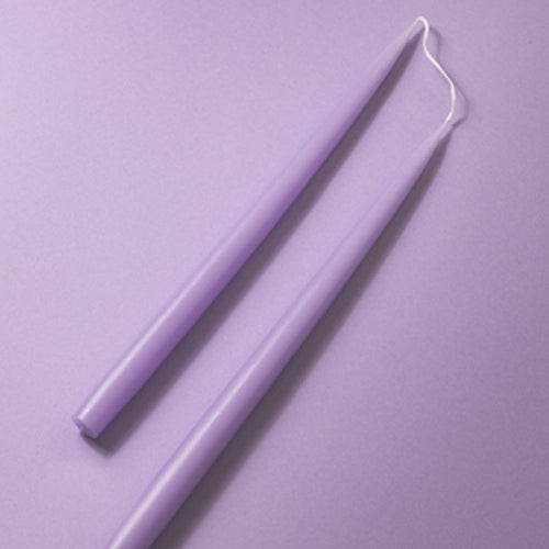 2 lilac coloured taper candles on a lilac background