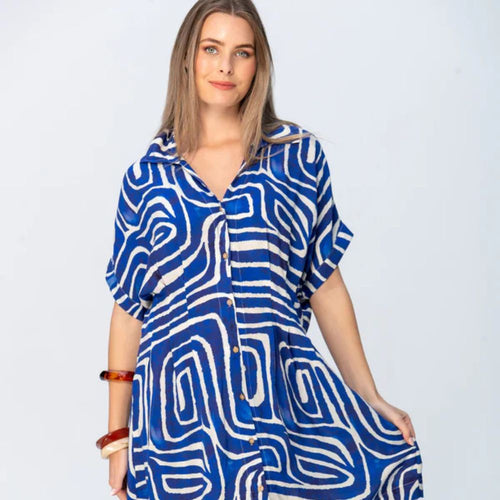 Woman wearing a blue and white patterned dress on a light gray background