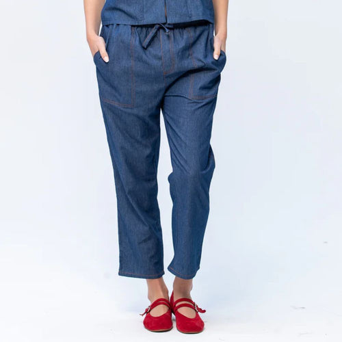 Blue denim pants worn by a person on a white background