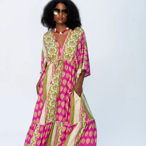 Woman wearing a colorful patterned dress on a light gray background