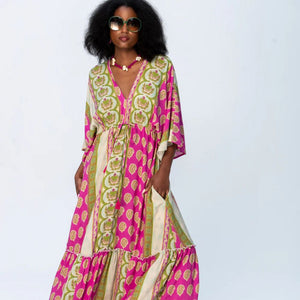 Woman wearing a colorful patterned dress on a light gray background