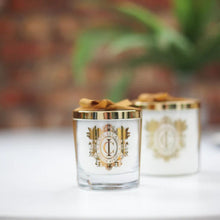 Load image into Gallery viewer, Two decorative candles with gold accents on a blurred background
