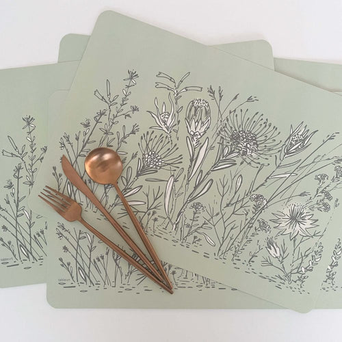 Set of 4 rectangular Tableart sage green placemats with grey & white fynbos design and copper cutlery on a white background