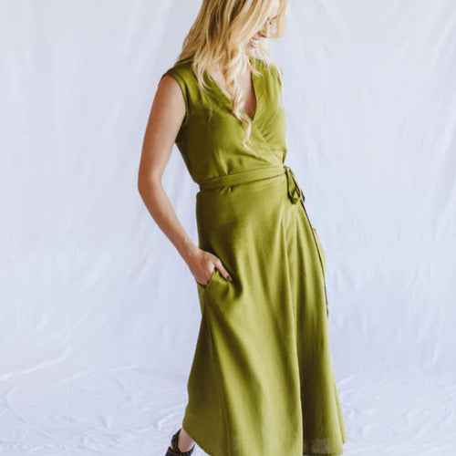 Woman wearing a green wrap dress against a white background