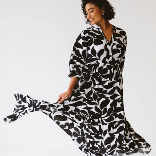 Woman wearing a black and white patterned dress on a white background