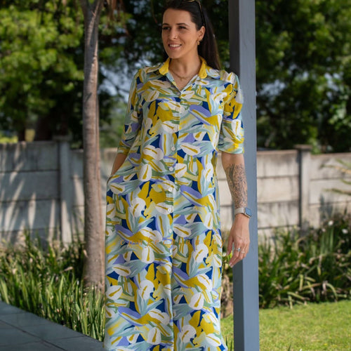 Woman wearing a colorful dress with abstract patterns in an outdoor setting