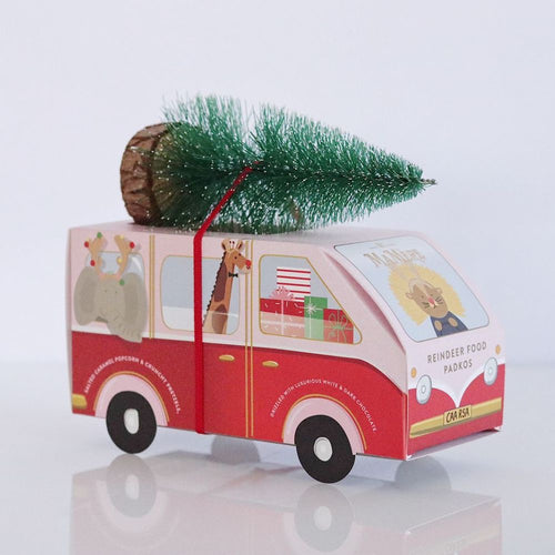 Red van-shaped gift box with a Christmas tree on top against a white background