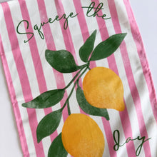 Load image into Gallery viewer, Tea towel with pink and white stripes, lemons, and leaves on a white background
