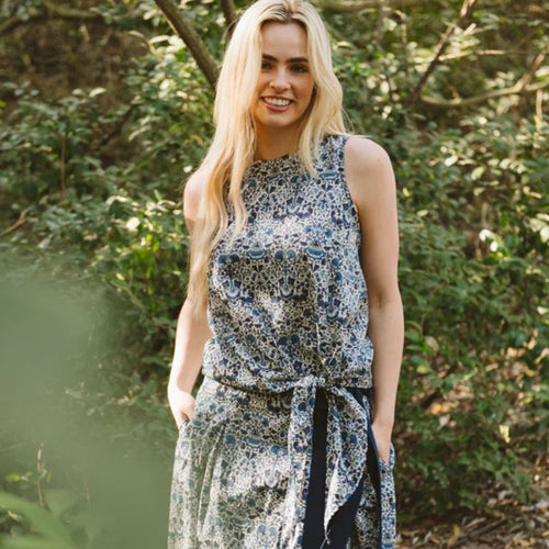 Woman wearing a floral dress standing in a forest setting