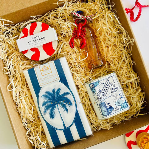 Gift box with assorted items including a set of red & white coin coasters, lobster bottle opener, paper napkins, and tin of sea salt.