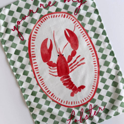 Green & white checkered tea towel with a red lobster design and text on a white background