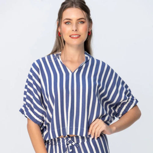 Woman wearing a blue and white striped outfit on a light gray background