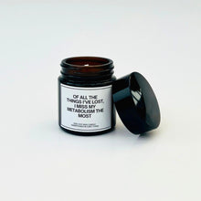 Load image into Gallery viewer, Candle in a black jar with a humorous label about metabolism on a white background

