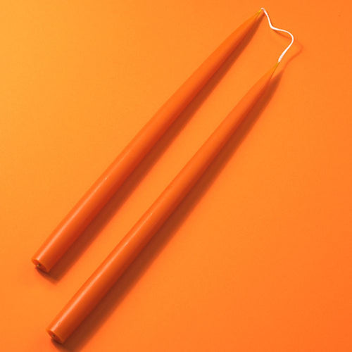 Two orange Miss Long candles on an orange background
