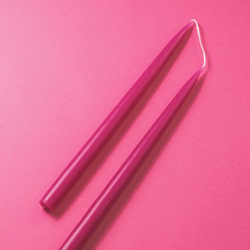 Two pink candles on a pink background