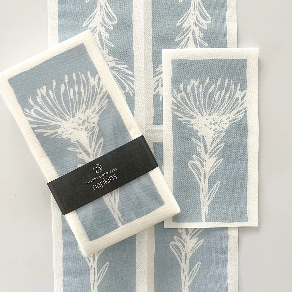 Set of 25 Tableart linen-feel slimline napkins. Blue & white protea pincushion flower design