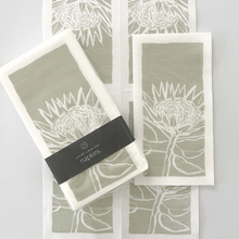 Load image into Gallery viewer, Set of 25 Tableart linen feel slim napkins with white protea image on a sage green background

