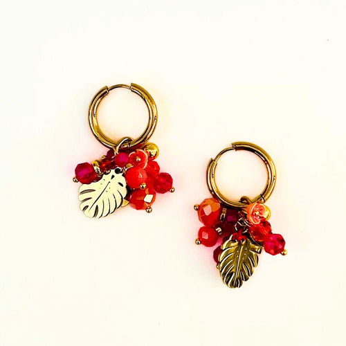Pair of hoop earrings with leaf and berry charms on a white background