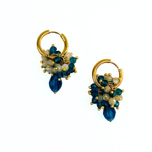 Gold hoop earrings with blue and white bead decorations on a white background