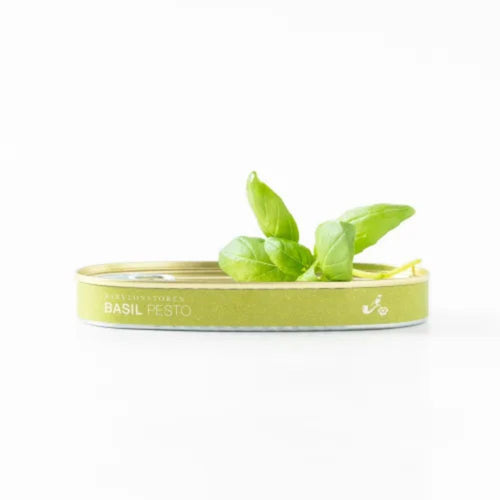 Babylonstoren Basil pesto tin with fresh basil leaves on a white background