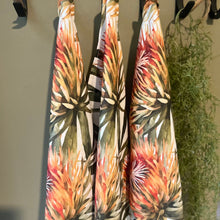 Load image into Gallery viewer, Three JW Designs Orange Pincushion print tea towels hanging on a rack with a plant in the background.
