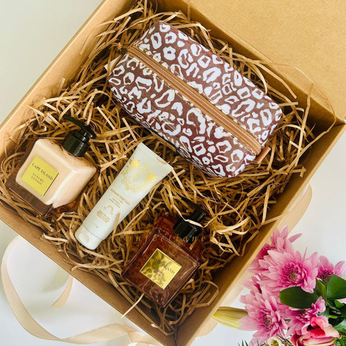 Gift set with leopard print pouch, skincare products, and flowers in a box