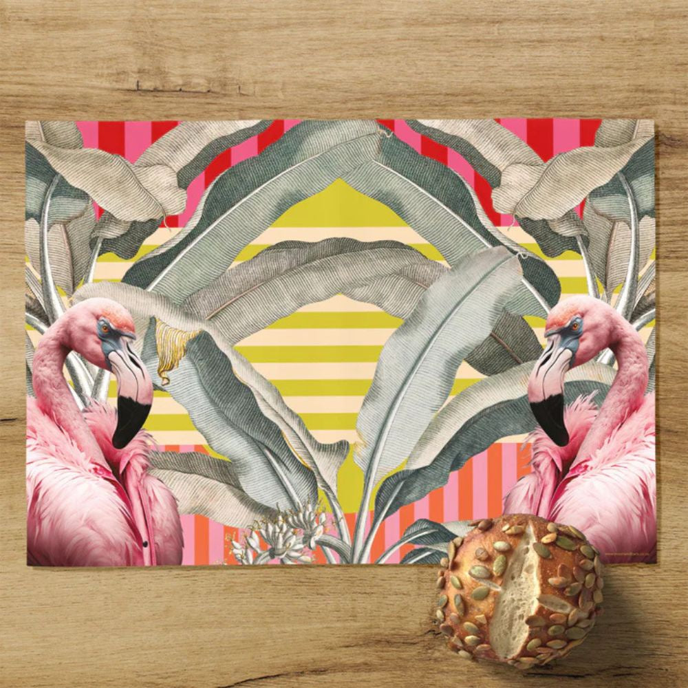 Decorative placemat with flamingo and leaf design on a wooden surface