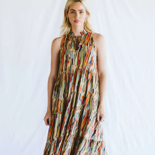 Woman wearing a colorful patterned dress against a white background