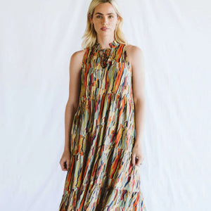 Woman wearing a colorful patterned dress against a white background