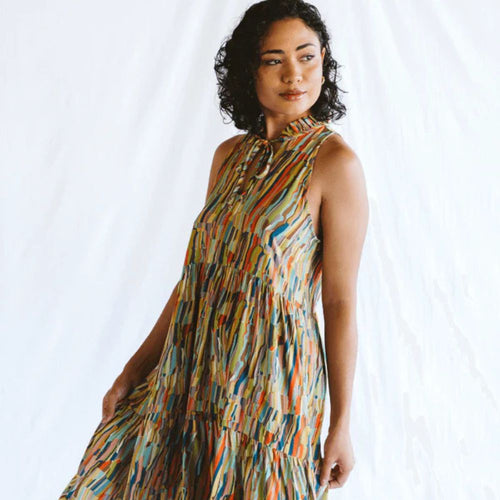 Woman wearing a colorful patterned dress against a white background