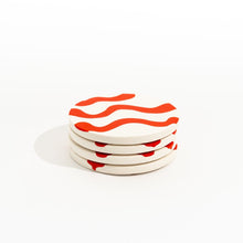 Load image into Gallery viewer, Stack of four ceramic coasters with red wavy patterns on a white background
