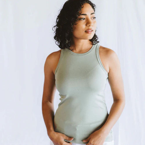 Woman wearing a light green tank top against a white background