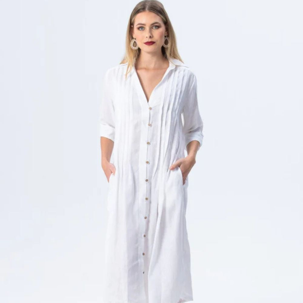 Woman wearing a long white dress with a plain background