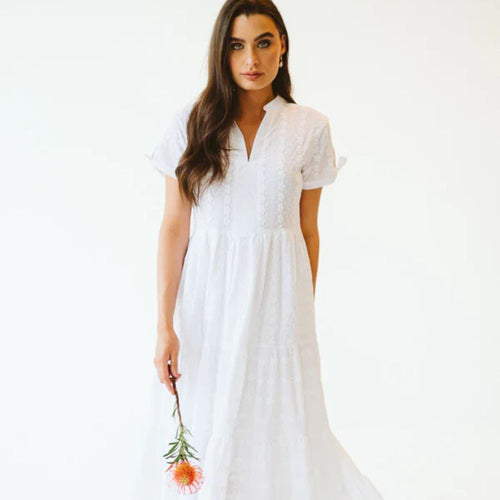 Woman wearing long white anglaise dress with short sleeves