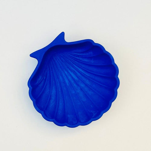 Blue shell-shaped trinket tray on a light beige background