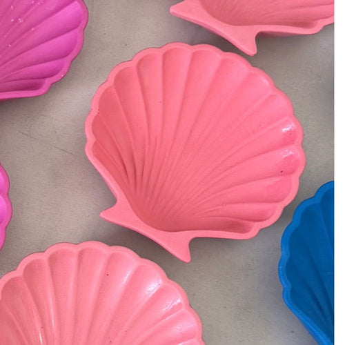 Pink shell-shaped trinket tray on a grey surface