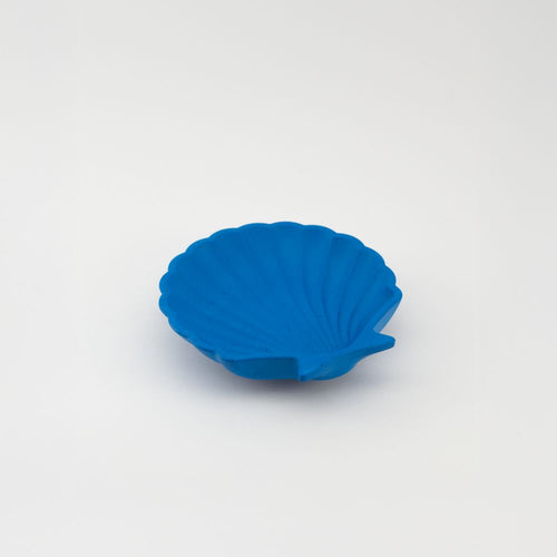 Blue shell-shaped trinket tray on a white background