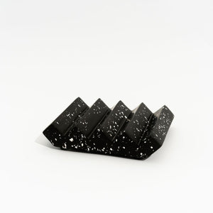 Black soap dish with white speckles on a white background