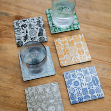 Load image into Gallery viewer, Set of six patterned coasters on a wooden surface with glasses.
