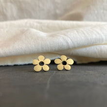 Load image into Gallery viewer, Gold flower-shaped earrings on a textured surface with a neutral background
