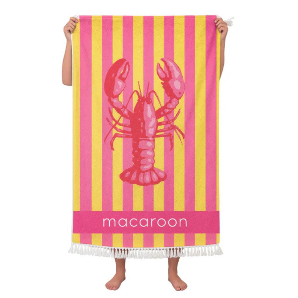 Towel with pink lobster design and yellow stripes, held by two hands on a white background.