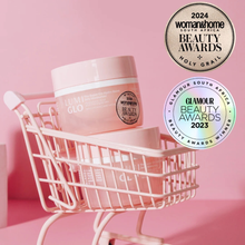 Load image into Gallery viewer, Pink skincare jar in a mini shopping cart with awards on a pink background
